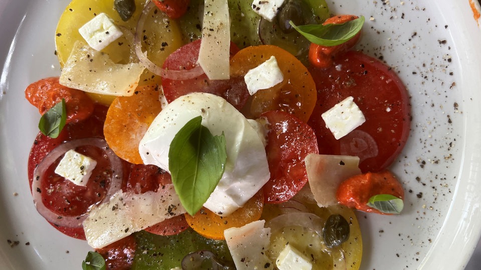 Ein Teller mit bunten Tomaten und Käse.