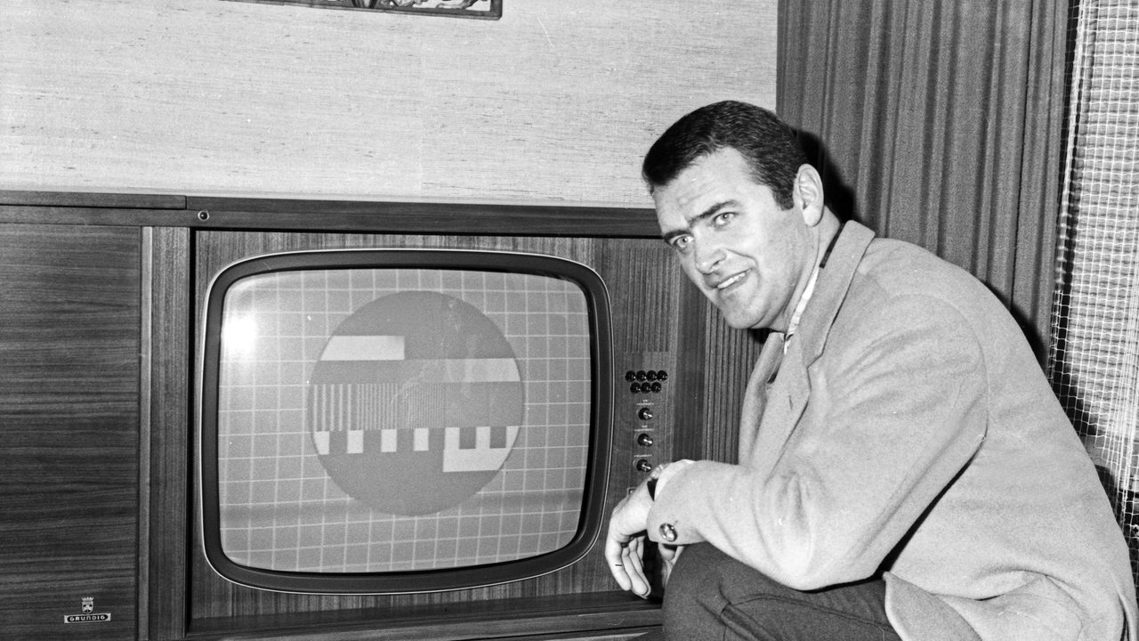 Ein Mann kniet vor seinem Fernseher, auf dem ein Schwarzweiß-Testbild zu sehen ist (Archivbild)
