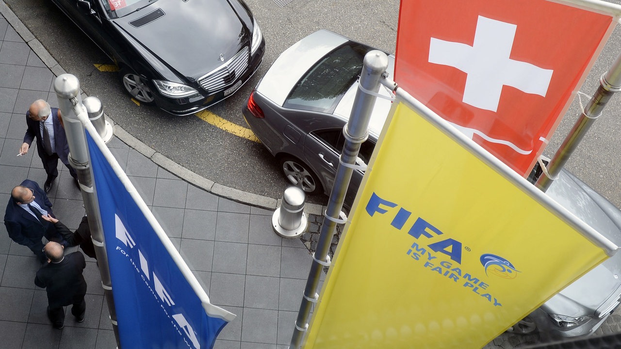 Fahnen der Fifa, Offizielle und große schwarze Autos vor einem Hotel in Zürich.