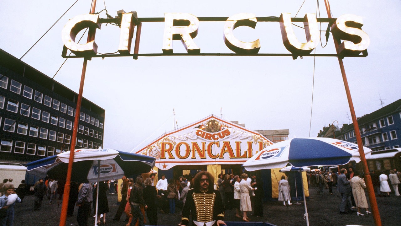 Zirkusdirektor Bernhard Paul am Eingang des von ihm und André Heller gegründeten Circus Roncalli im Jahre 1980
