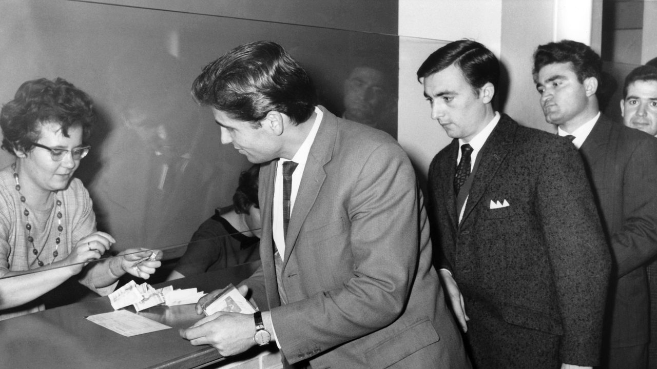 Gastarbeiter aus Italien tauschen am 15.12.1962 auf der Post in Wolfsburg DM gegen Lire (Archivbild)