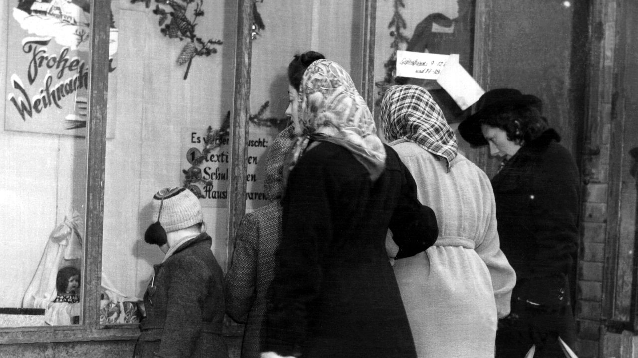 Passanten betrachten 1945 das weihnachtlich dekorierte Schaufenster eines Geschäftes in Frankfurt am Main. (Archivbild)