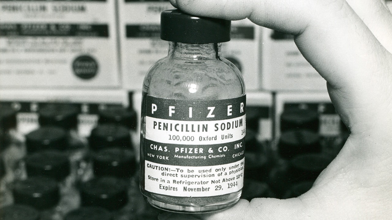Eine Hand hält auf einem Foto aus den frühen 1940er Jahren ein Fläschchen Penicillin.