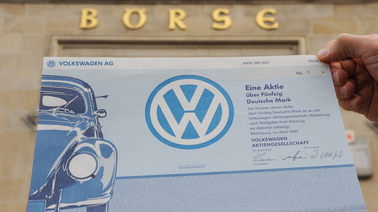 Ein Mitarbeiter der Niedersächsischen Börsen AG hält vor dem Börsengebäude in Hannover ein historisches Wertpapier der Volkswagen AG in der Hand (Archivbild)
