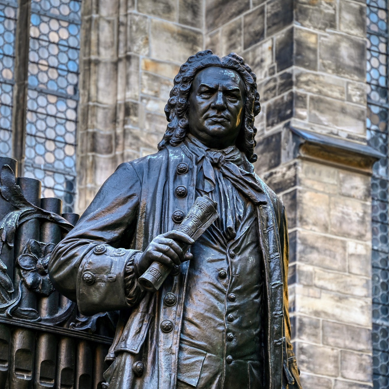 Nahaufnahme des historischen Denkmals des Johann Sebastian Bach in der Leipziger Innenstadt, im Hintergrund die Thomaskirche