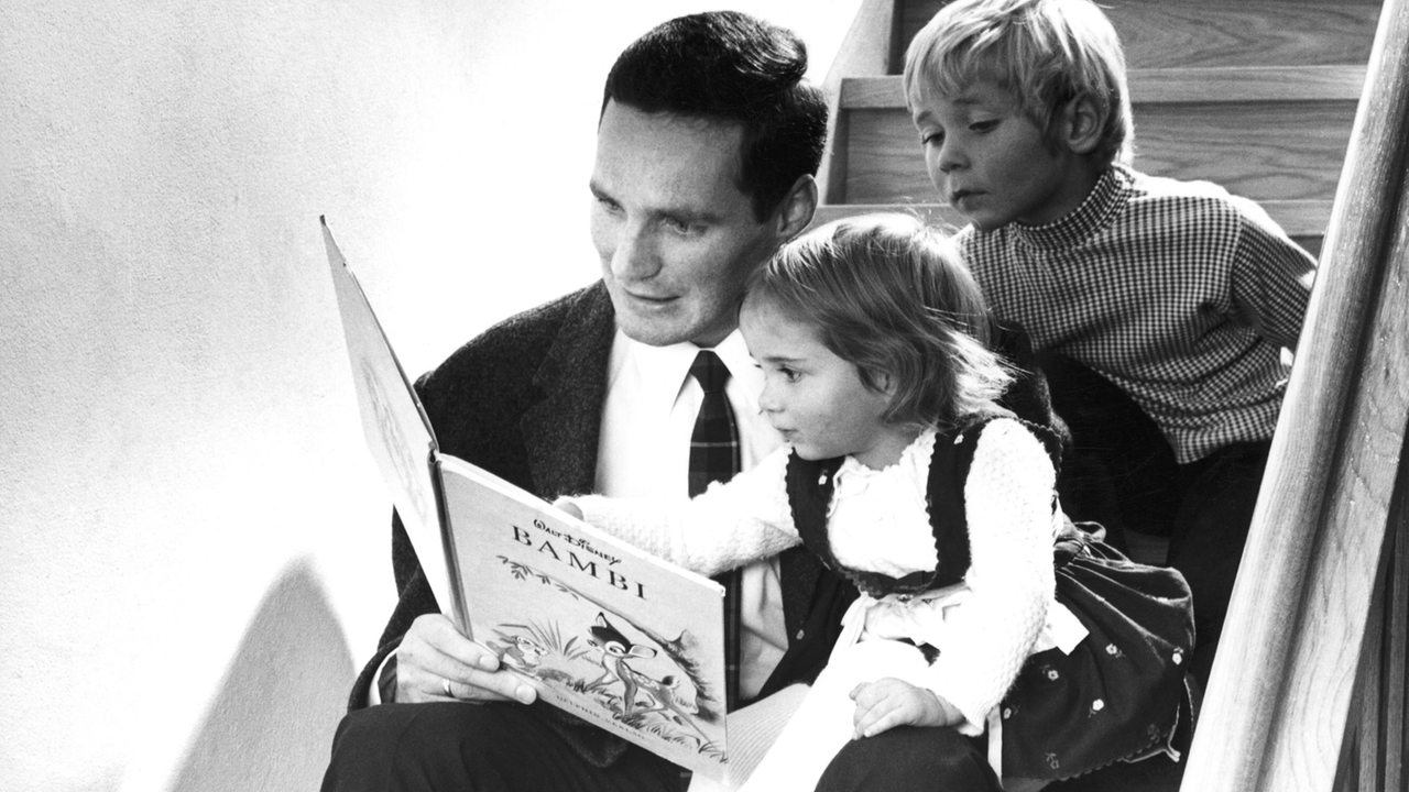 Vater mit zwei Kindern liest Bambi-Buch, 60er Jahre