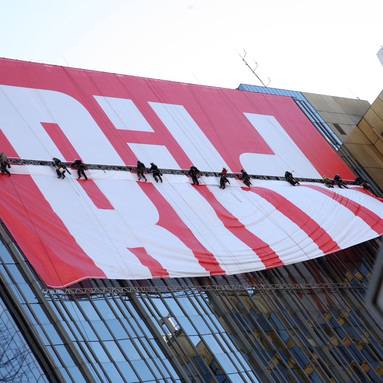 Kletterer befestigen am 18.03.2008 das Logo der Bildzeitung an der Fassade des Axel Springer-Hochhauses in Berlin; im Vordergrund das Straßenschild der "Axel-Springer-Straße". 