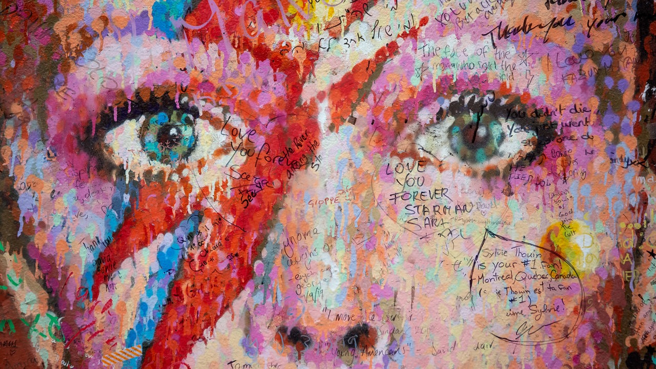 David Bowies Gesicht als Wandgemälde in London, versehen vielen kleinen Botschaften