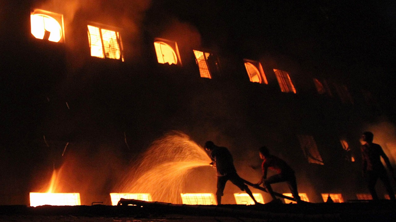 Männer bekämpfen einen großen Brand in einer Textilfabrik in Dhaka.