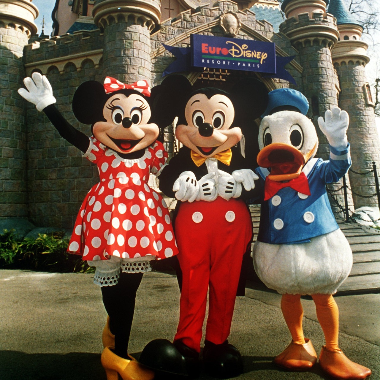Minnie Mouse, Mickey Mouse und Donald Duck vor dem Dornröschenschloss im Vergnügungpark Euro Disneyland im französischen Marne-la-Vallee bei Paris im April 1992.