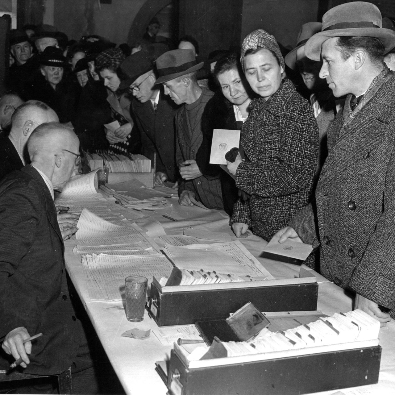 Historische Aufnahme zeigt Bürger, die sich in der Nachkriegszeit in einem Wahllokal drängeln