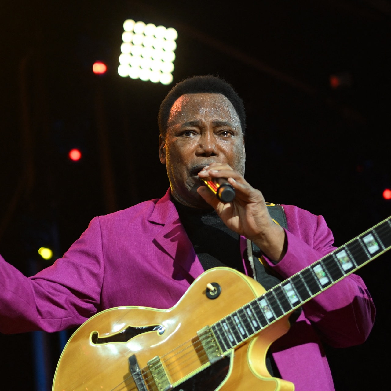 Jazzlegende George Benson auf der Bühne mit Mikro und Gitarre 2022 in Frankreich.