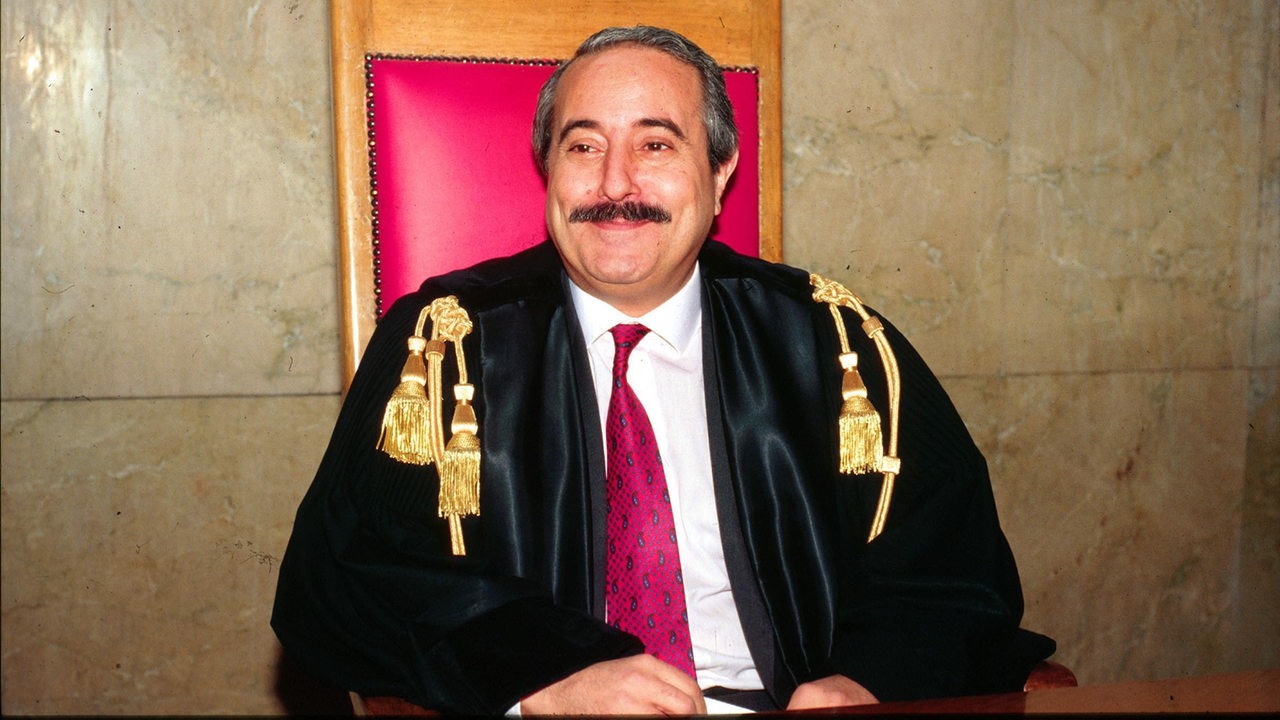 Der Richter und Mafiajäger Giovanni Falcone sitzt lächelnd auf dem Richterstuhl