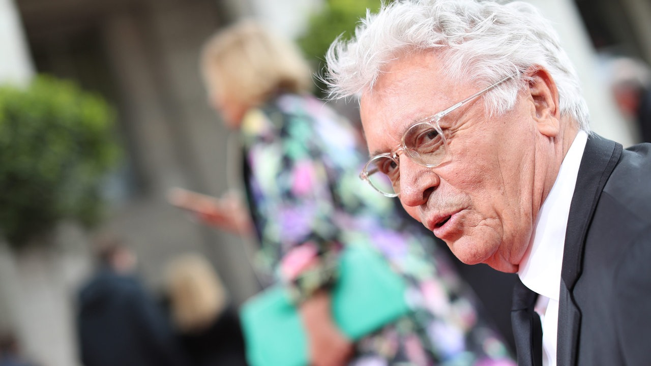 Henry Hübchen schaut lachend von rechts in Bild