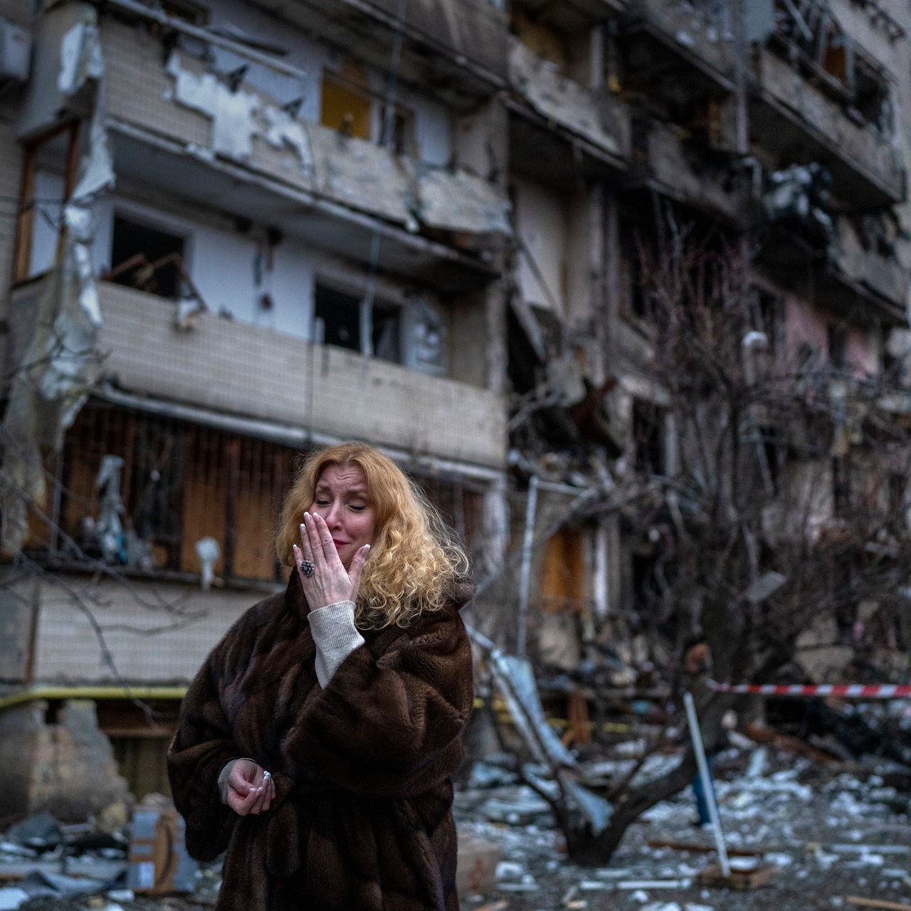 Eine weinende Ukrainerin steht vor ihrem zerstörten Haus in Kiew
