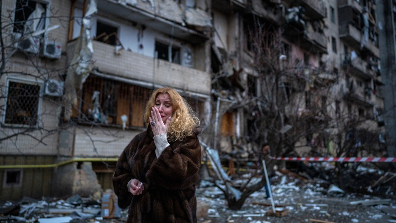 Eine weinende Ukrainerin steht vor ihrem zerstörten Haus in Kiew