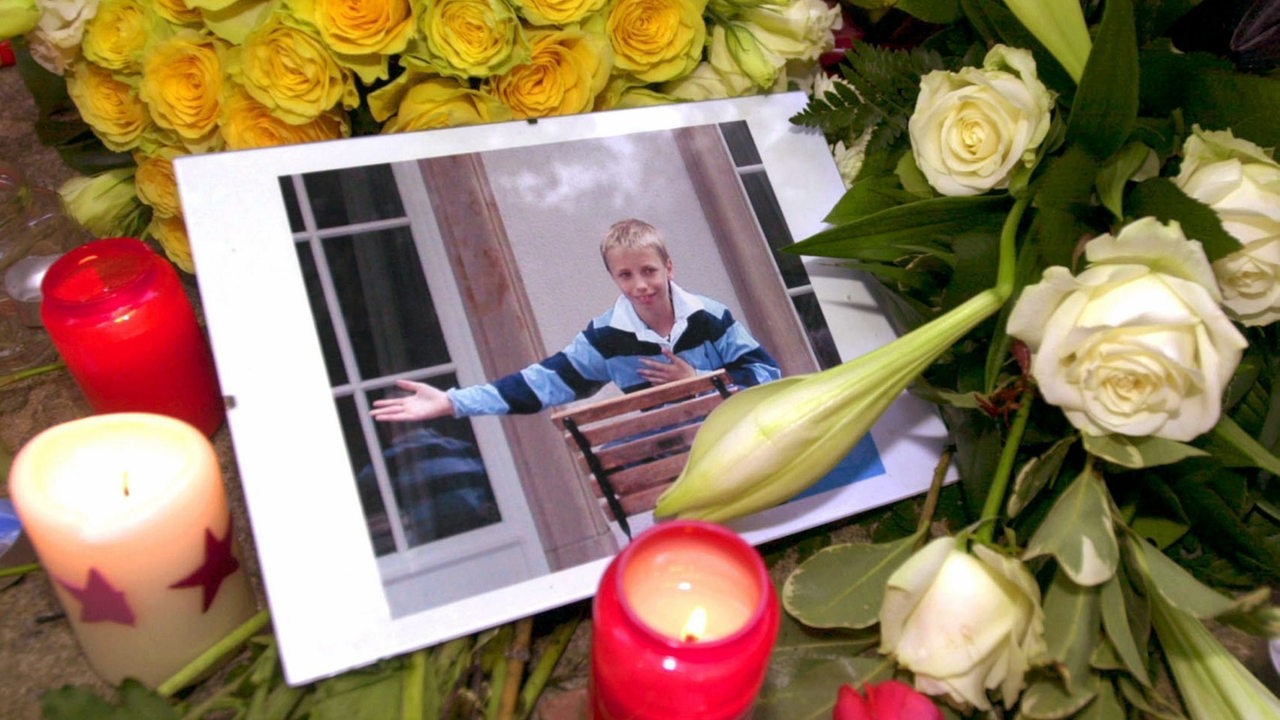 Ein Foto des 11jährigen Bankierssohns Jakob Metzler zwischen Grablichtern und Blumensträußen