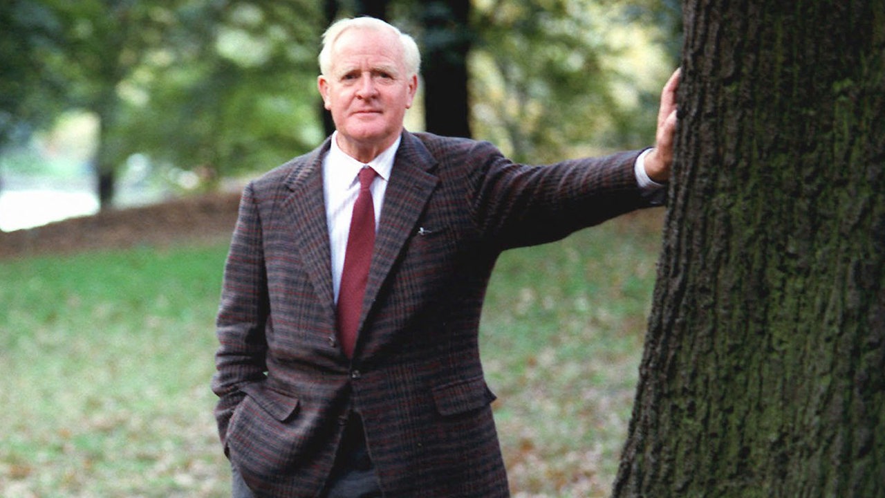 Porträt von John Le Carré 1996, an einen Baum lehnend