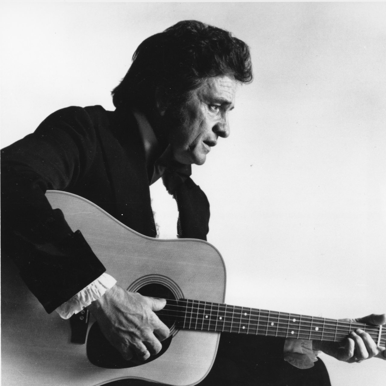 Johnny Cash spielt auf einem undatierten Foto Gitarre. 