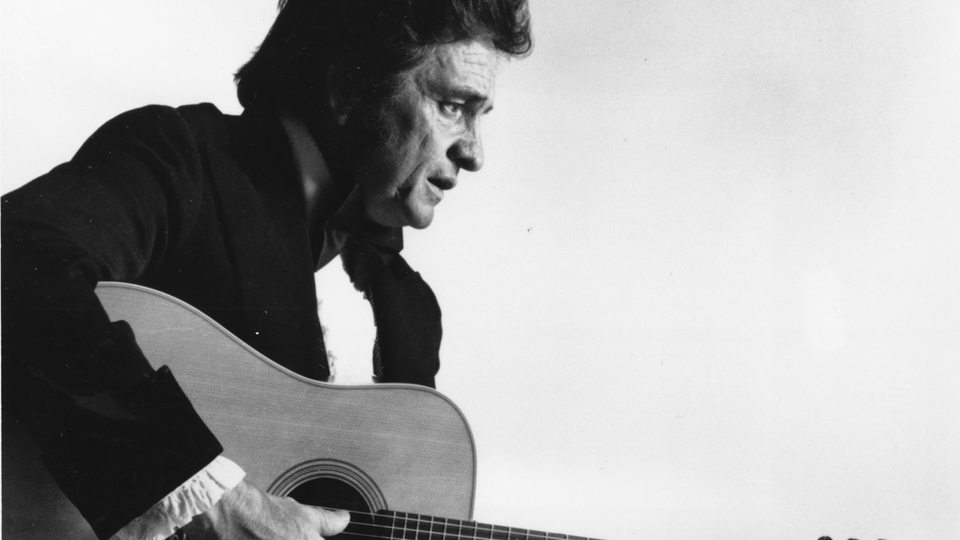 Johnny Cash spielt auf einem undatierten Foto Gitarre. 