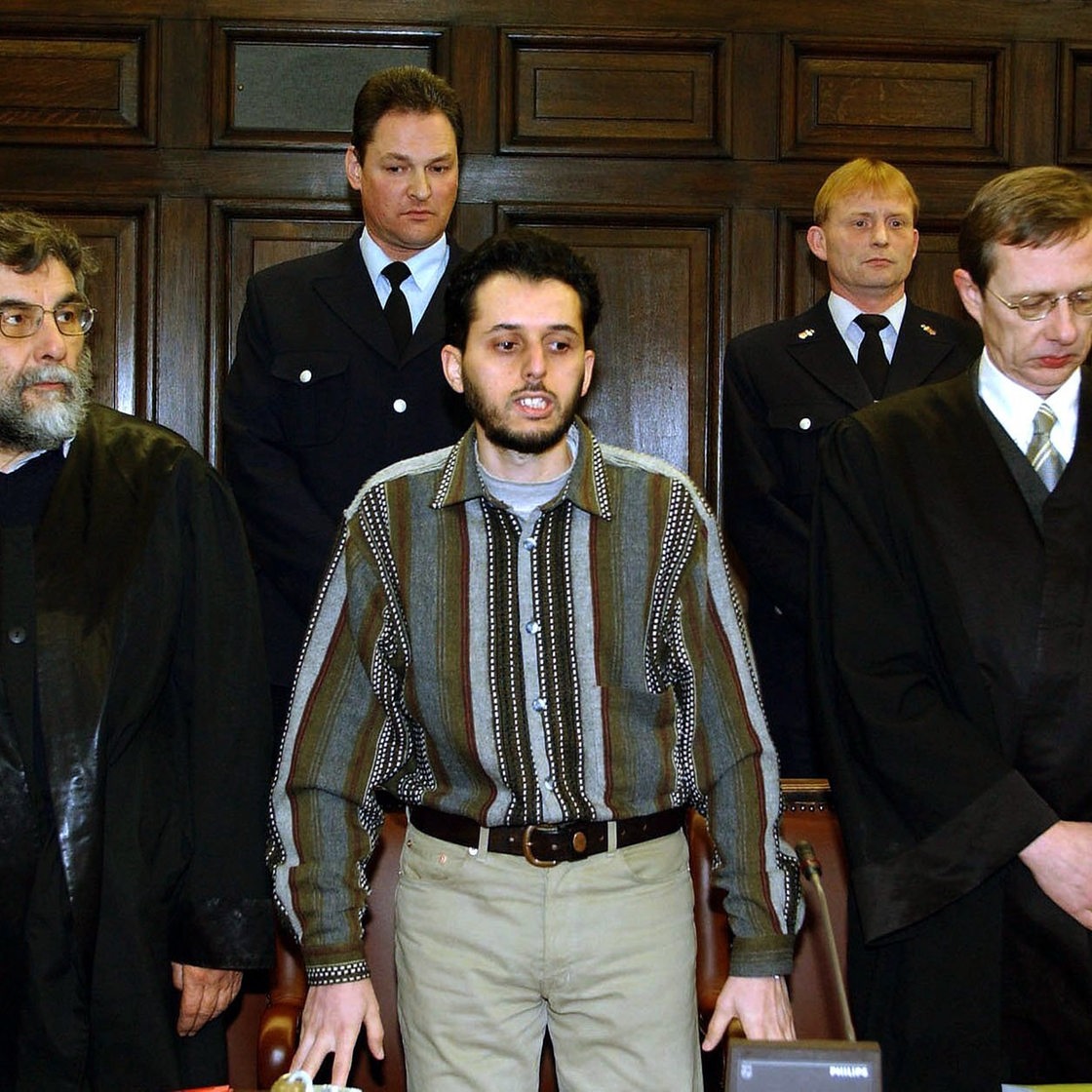 Der Angeklagte Mounir El Motassadeq steht vor der Urteilverkündung am 19.2.2002 im Verhandlungssaal des Landgerichts in Hamburg zwischen seinen Verteidigern Hartmut Jacobi (l) und Hans Leistritz (r).