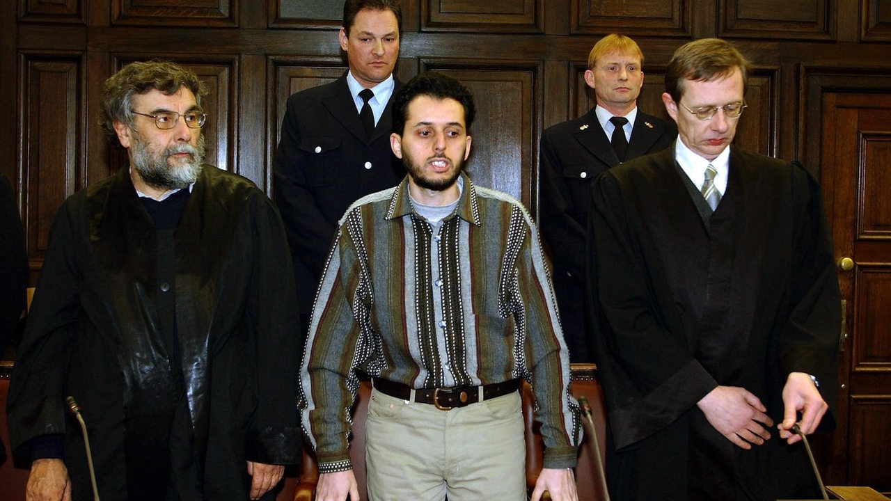 Der Angeklagte Mounir El Motassadeq steht vor der Urteilverkündung am 19.2.2002 im Verhandlungssaal des Landgerichts in Hamburg zwischen seinen Verteidigern Hartmut Jacobi (l) und Hans Leistritz (r).
