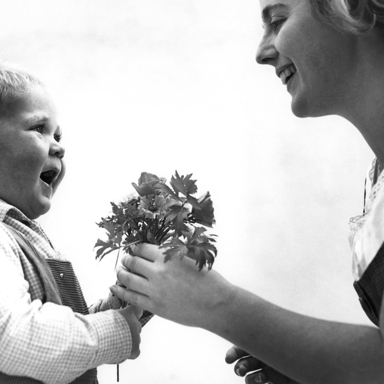 Ein junge überreicht seiner Mutter einen kleinen Blumenstrauss zum Muttertag (Archivbild)