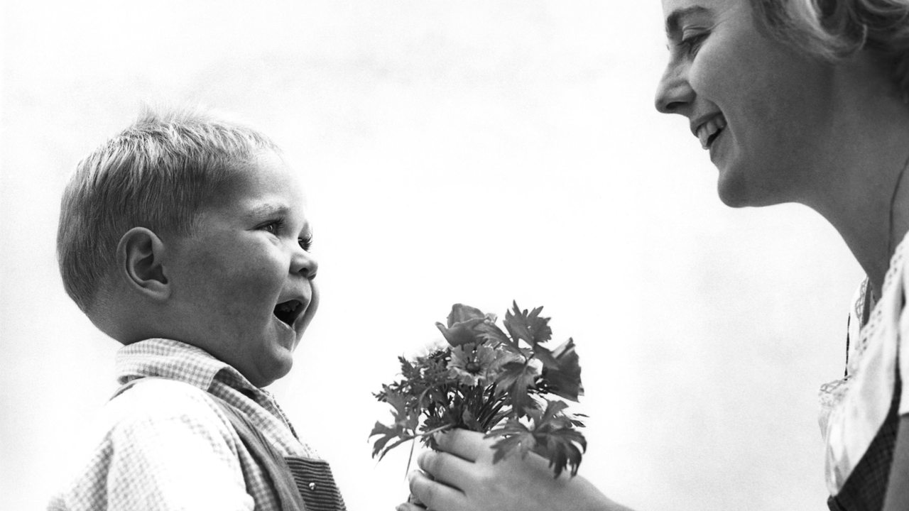 Ein junge überreicht seiner Mutter einen kleinen Blumenstrauss zum Muttertag (Archivbild)