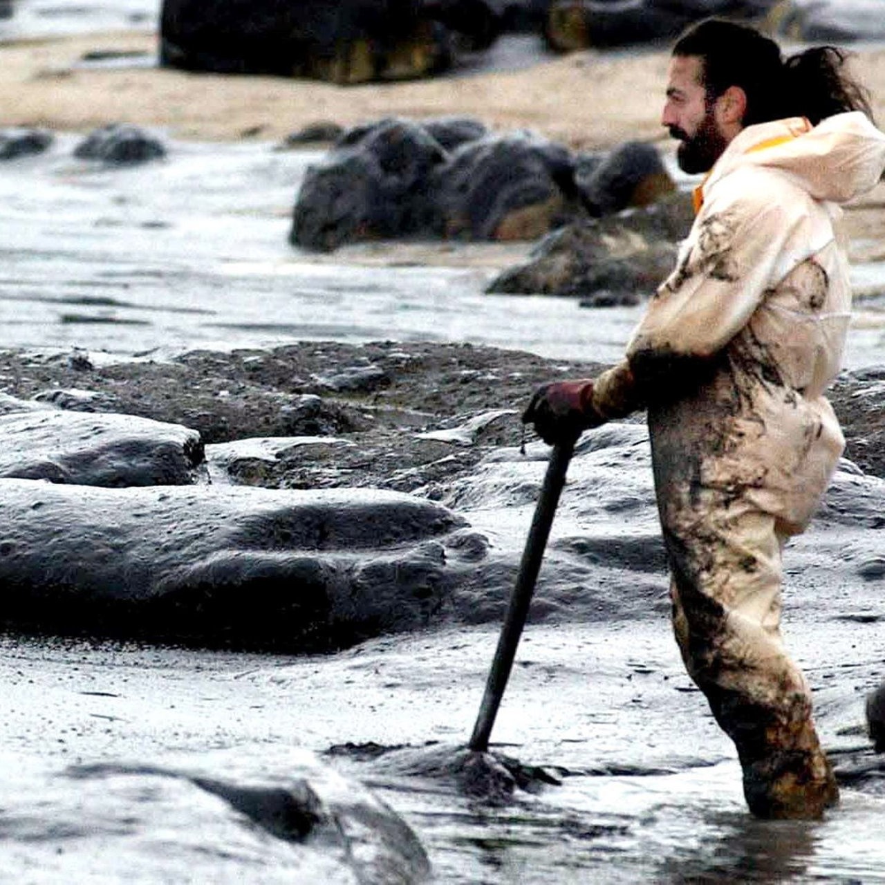 Ein freiwilliger Helfer macht eine Pause, als er 2002 den zähen Ölschlamm vom Cans-Strand auf der spanischen Insel Ons wegschaufelt. 