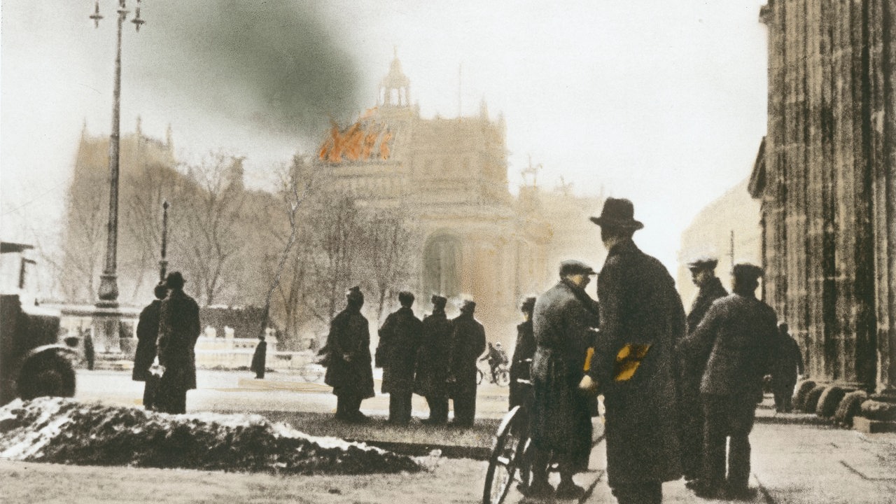 Blick vom Brandenburger Tor auf das brennende Reichstagsgebäude am Morgen des 28. Februar 1933