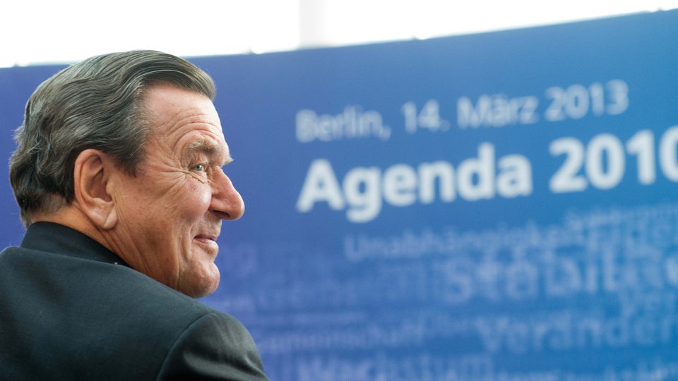 Gerhard Schröder vor einer Plakatwand "Agenda 2010"