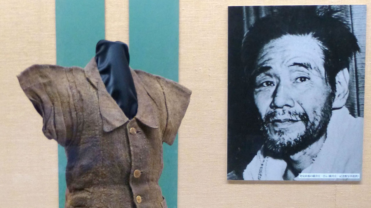 Ein Porträt des Soldaten Shoichi Yokoi, der fast 30 Jahre in Guam im Dschungel lebte, links seine Kleidung in einer Ausstellung (Archivbild)
