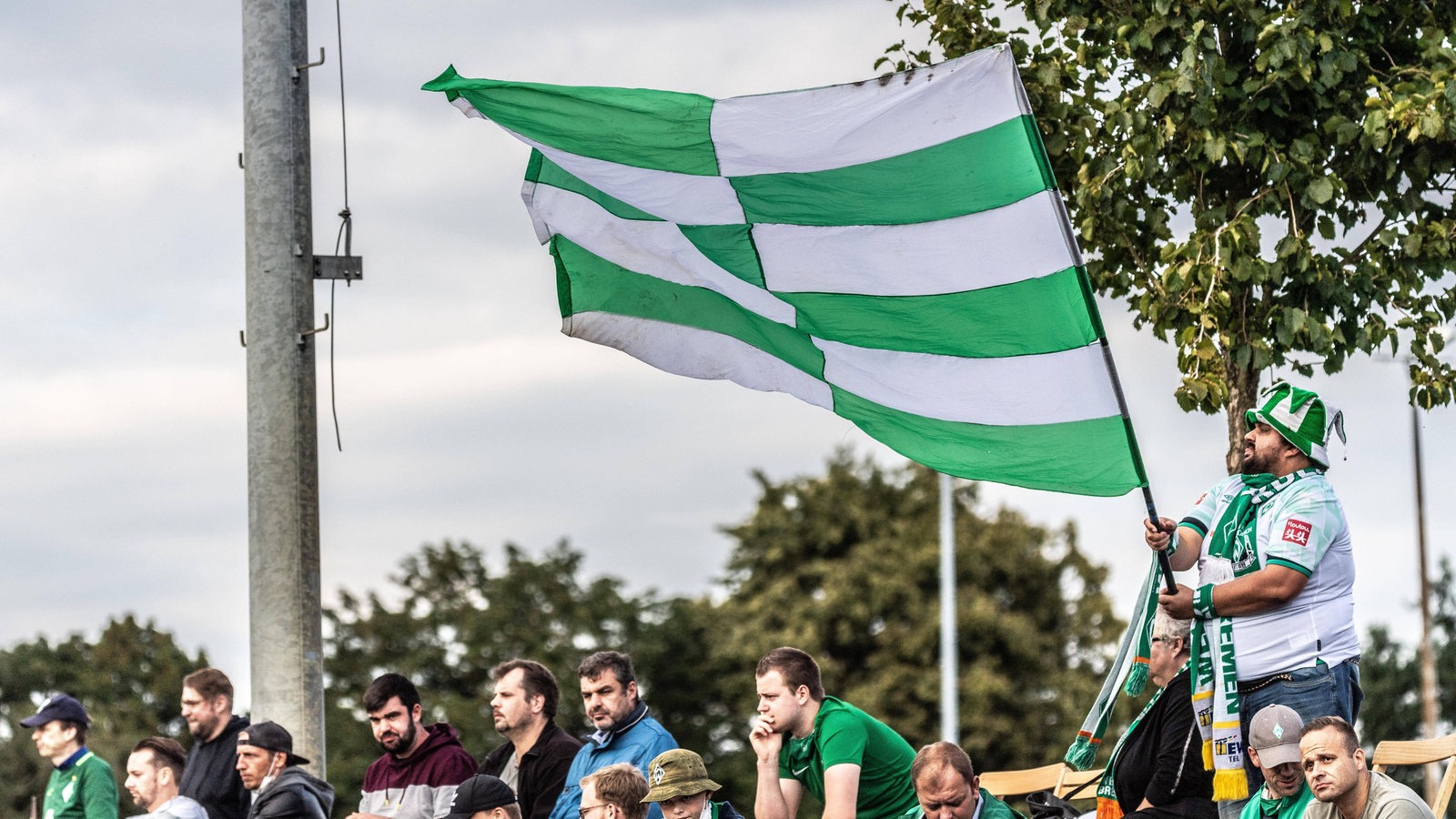  Ein Werder Fan schwingt die Fahne freut sich wieder im Stadion sein zu dürfen