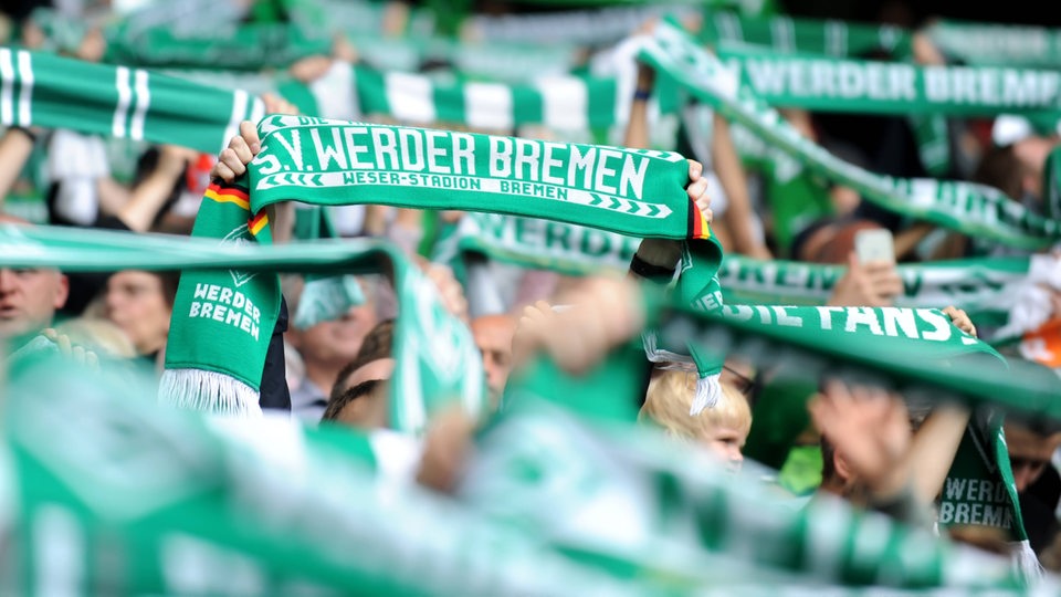 Werder-Fans aus Bremen heben ihren Schal in die Luft