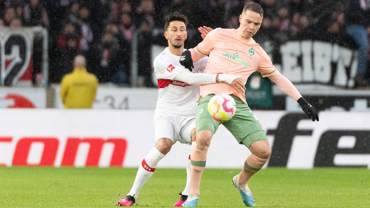 Werder-Spieler Niklas Schmidt im Zweikampf mit einem Stuttgarter Spieler im strömenden Regen.
