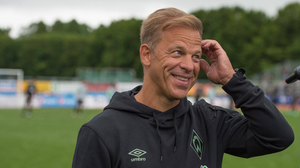 Werder Trainer Markus Anfang kratzt sich am Kopf und lächelt breit