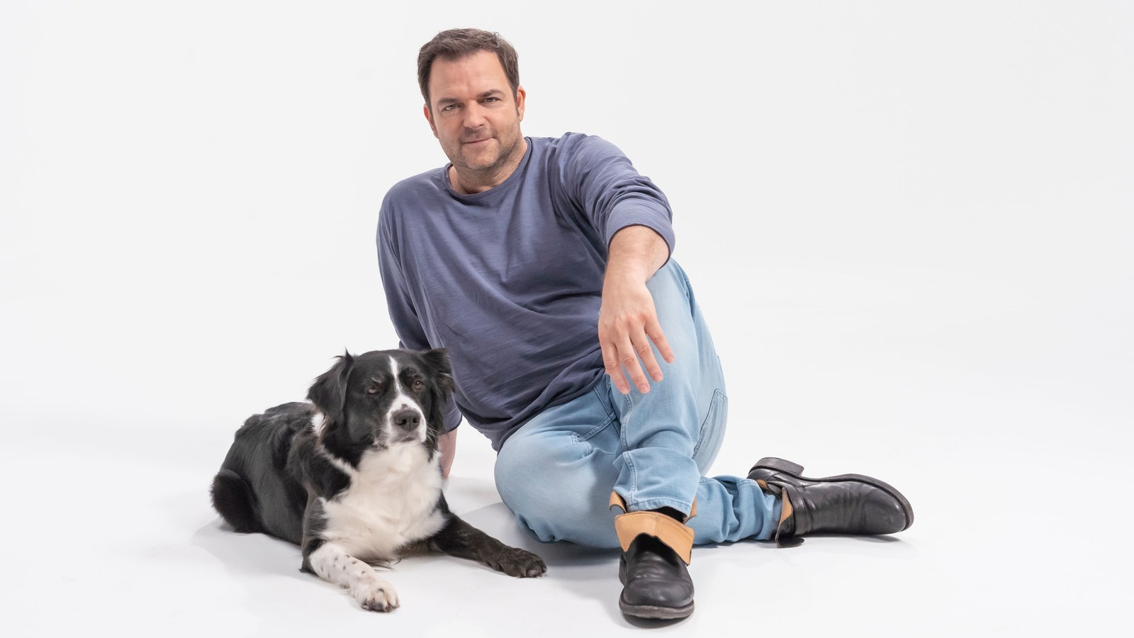 Martin Rütter sitzt mit Hunden auf Couch