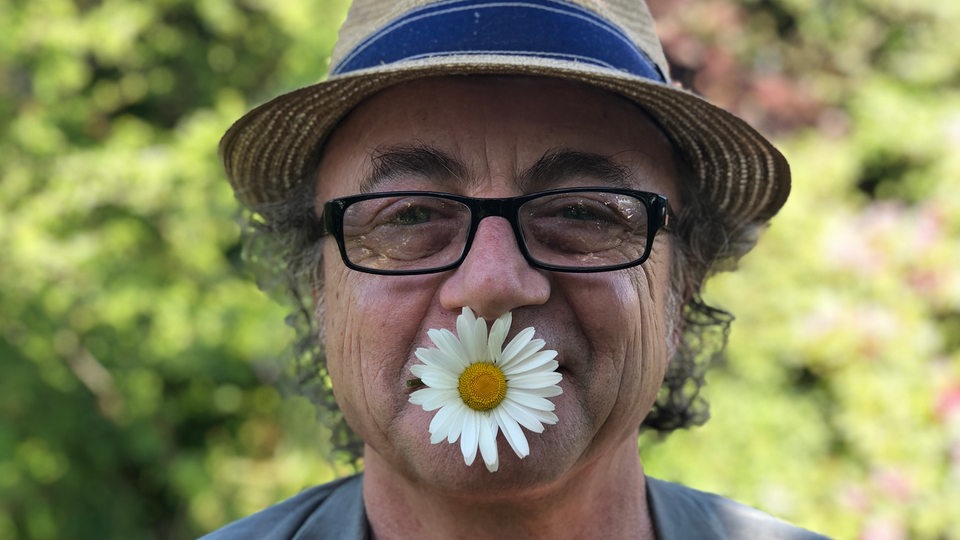Reporter Jens Schellhass mit einer Blume in Mund