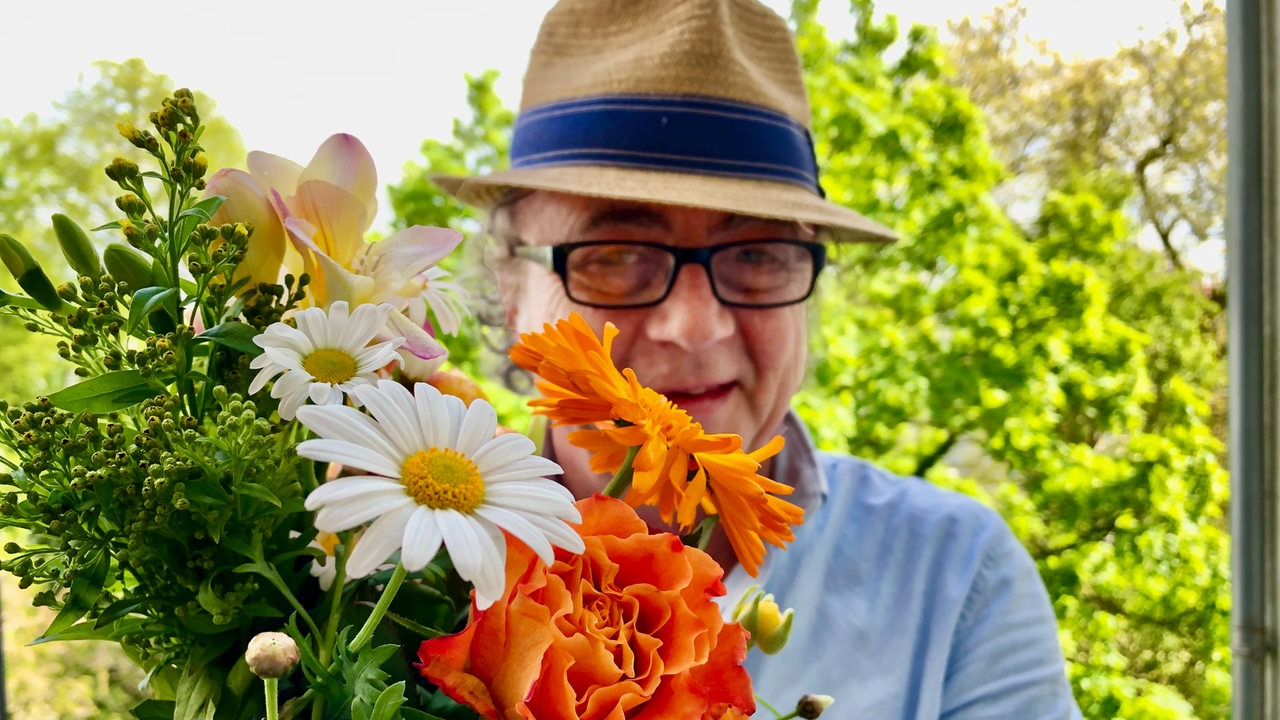 Der Parzellist mit einem Blumenstrauss in der Hand 