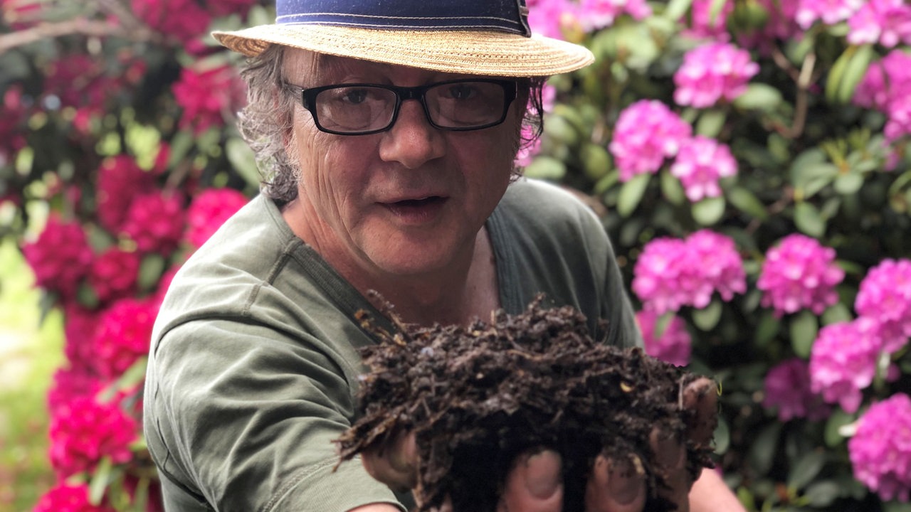 Jens Schellhass hält Kompost-Erde in der Hand