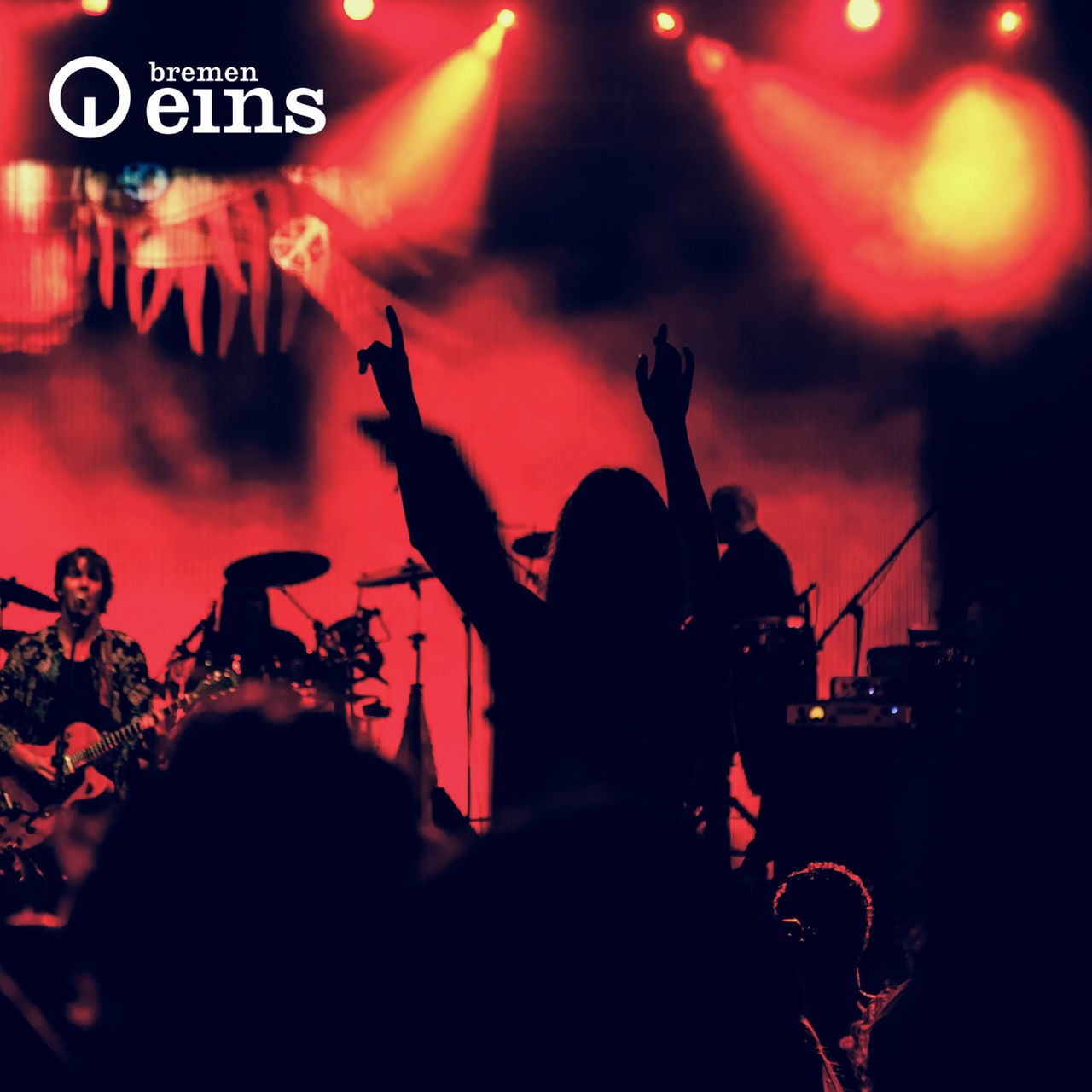 Silhouette von tanzenden Menschen dahinter eine Band auf der Bühne