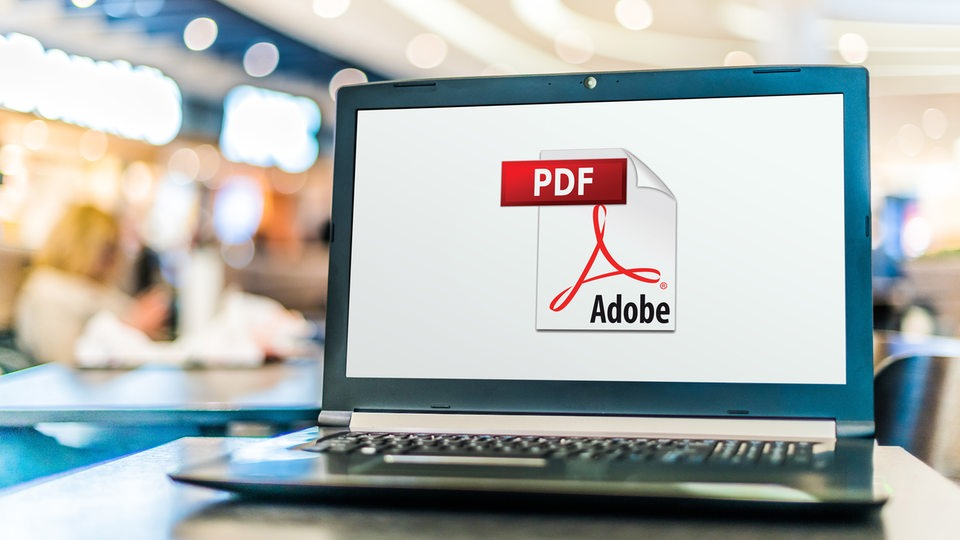 Auf einem Laptop ist das Logo von Adobe Acrobat zu sehen (PDF)