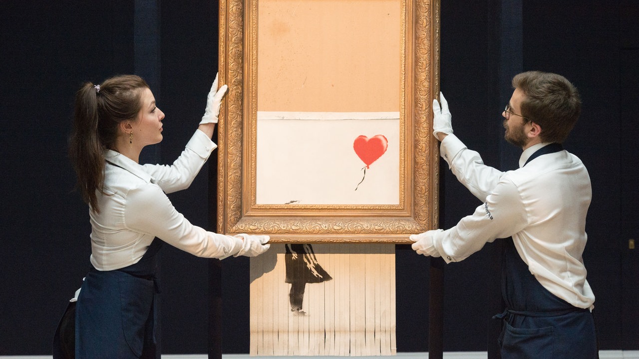 Das Gemälde von Banksy "Love Is In The Bin", wird auf einer Auktion präsentiert und von durch einen Selbstzerstörungsmechanismus geschreddert.