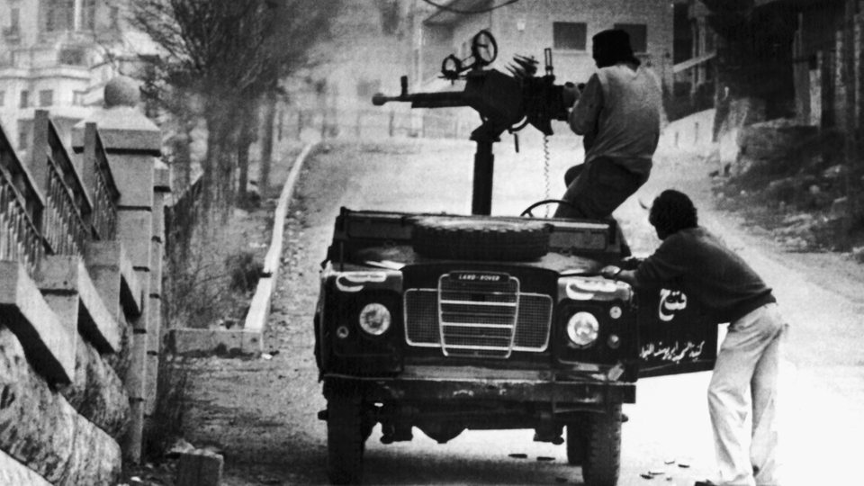 Ein Auto mit aufgebautem Maschinengewehr von palästinensischen Fatah-Kämpfern feuert auf syrische Truppen.