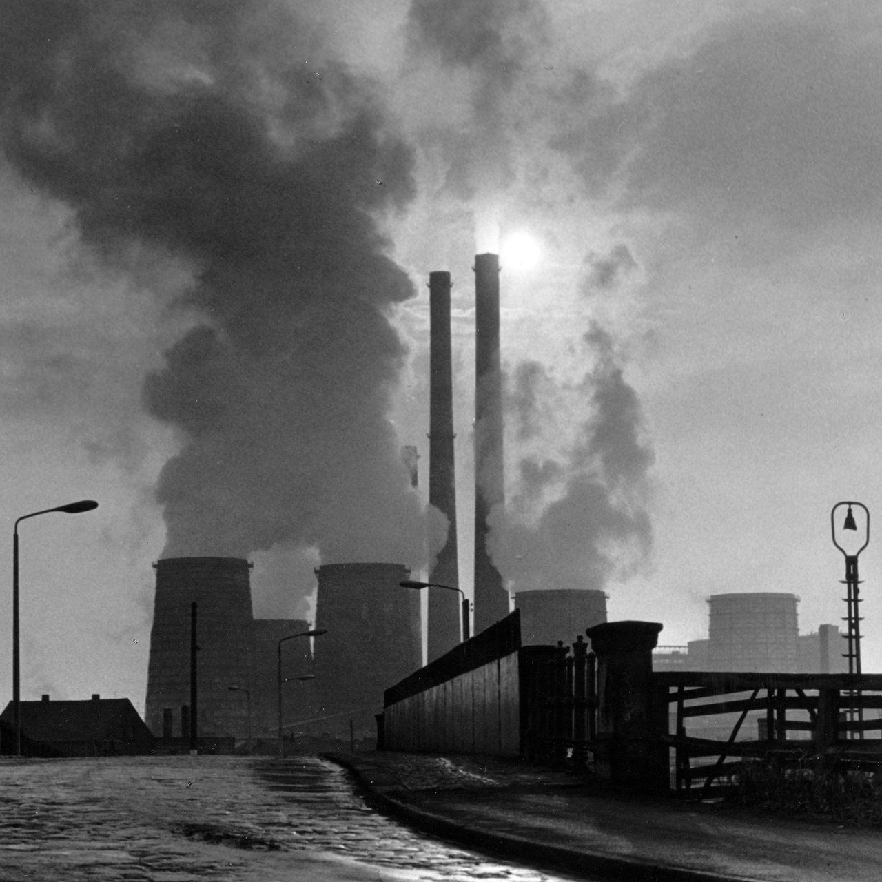 Wolken aus den Kühltürmen steigen in den dunstigen Himmel über dem Chemiekombinat Bitterfeld (Foto aus dem Jahr 1970). 