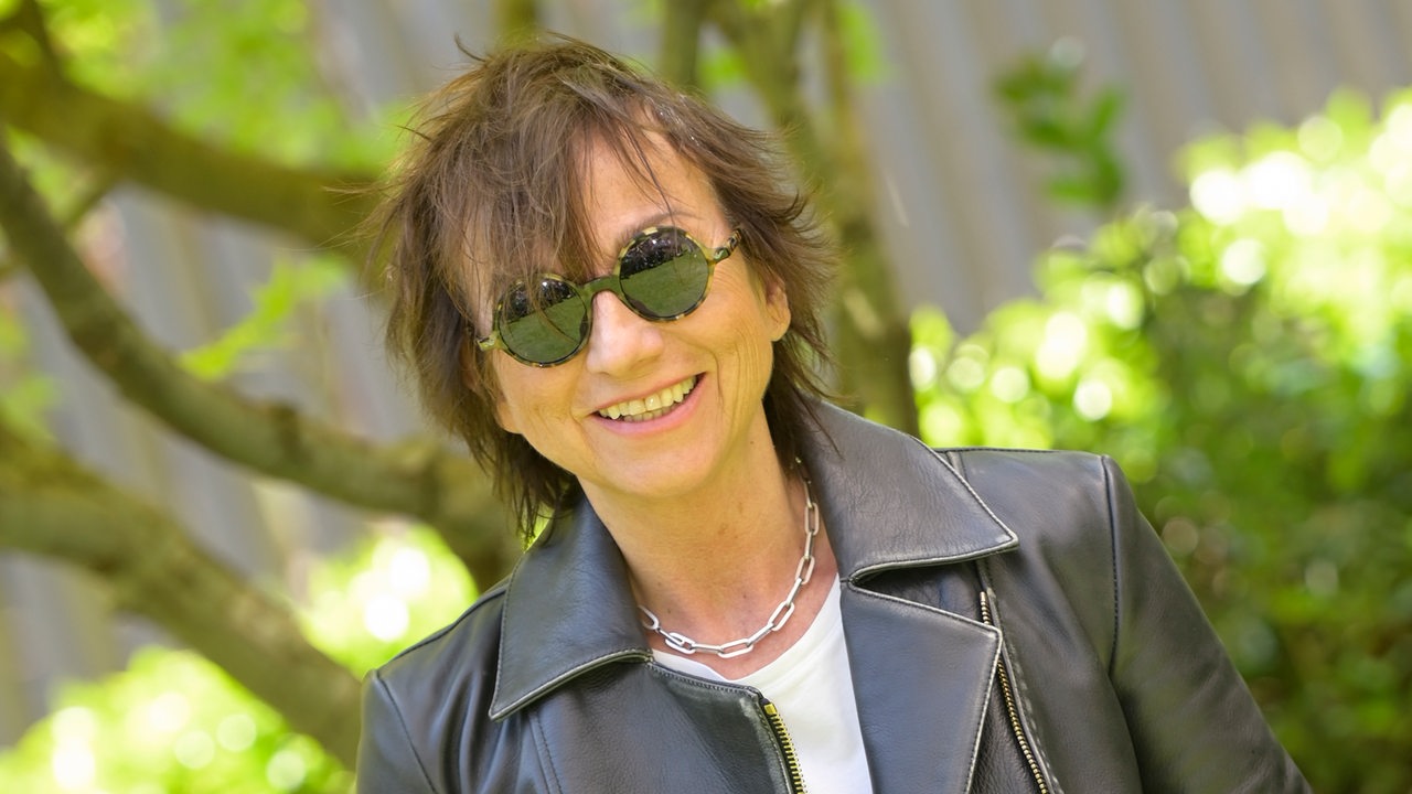 Gianna Nannini mit Sonnenbrille und Lederjacke im Grünen (2022).