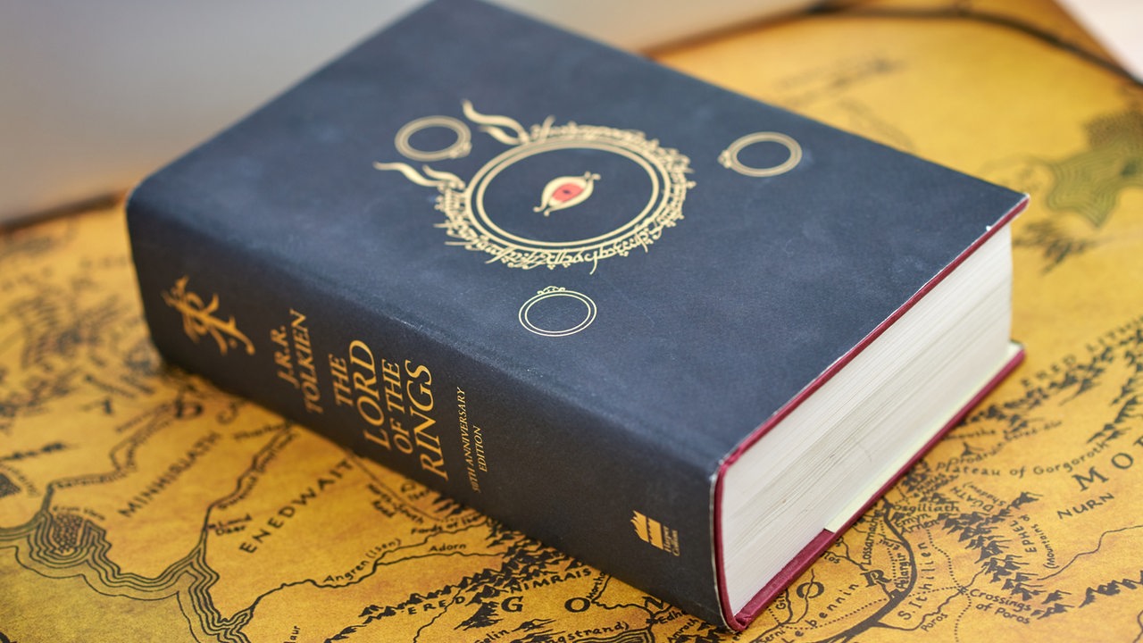 Eine dicke gebundene Ausgabe von J.R.R. Tolkiens "The Lord of the rings" liegt auf einer Karte von "Mittelerde".