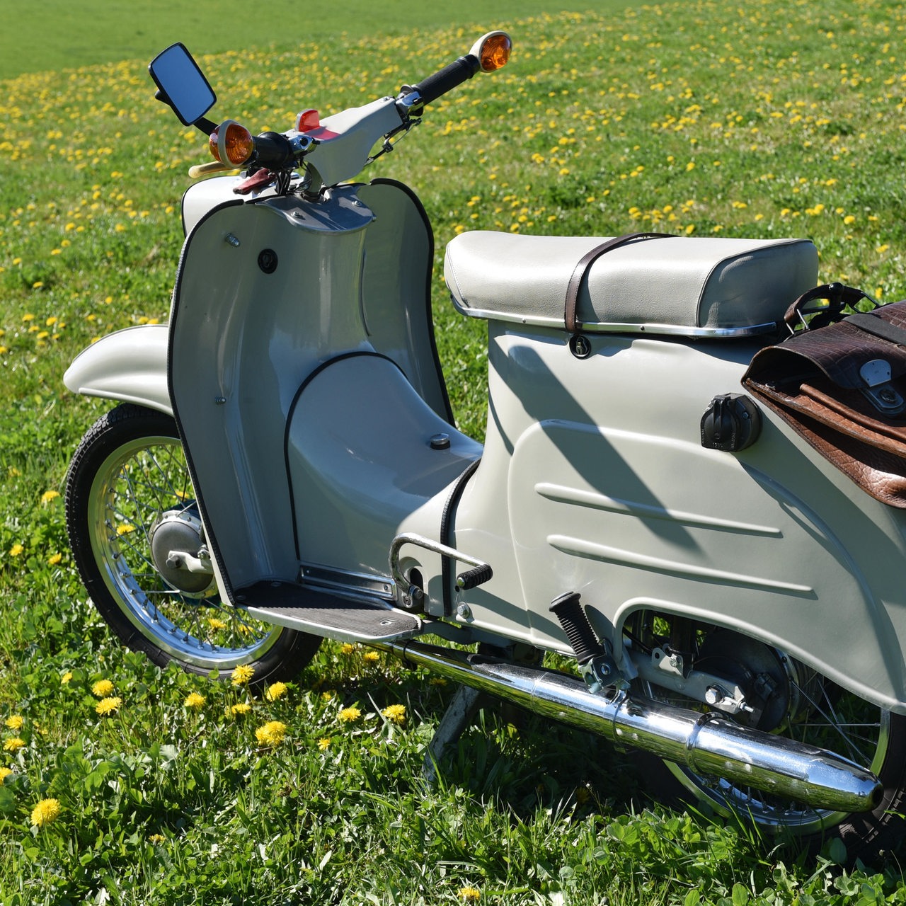 Das DDR-Moped KR 51 (Schwalbe) steht auf einer Wiese.