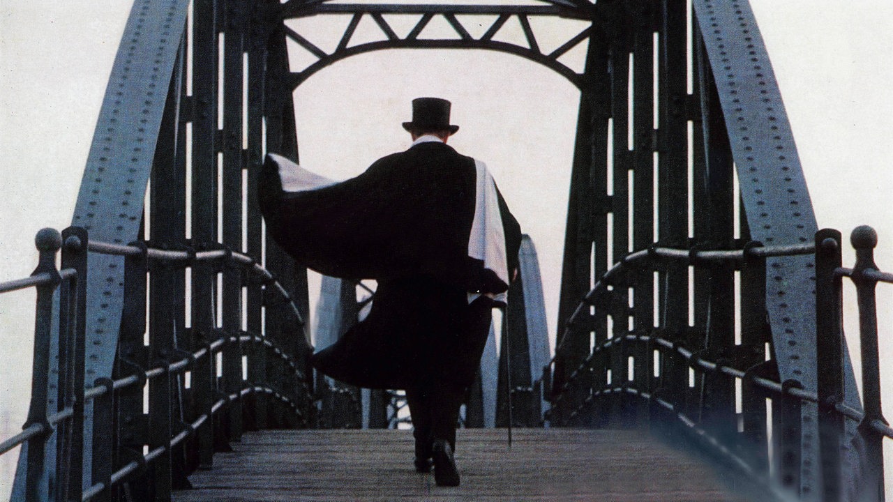 "Der Lord von Barmbeck" mit Zylinder und Mantel, Rückenansicht, geht über eine Brücke (Szenenbild aus der Verfilmung von 1973)