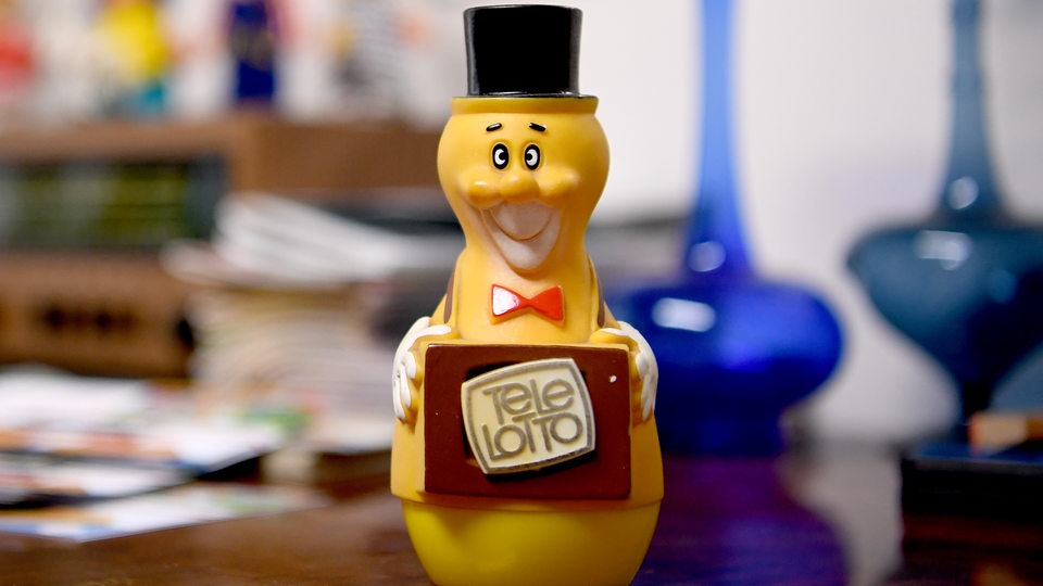 Die DDR-Werbefigur "Tele-Lotto-Männchen" steht auf einem Tisch.